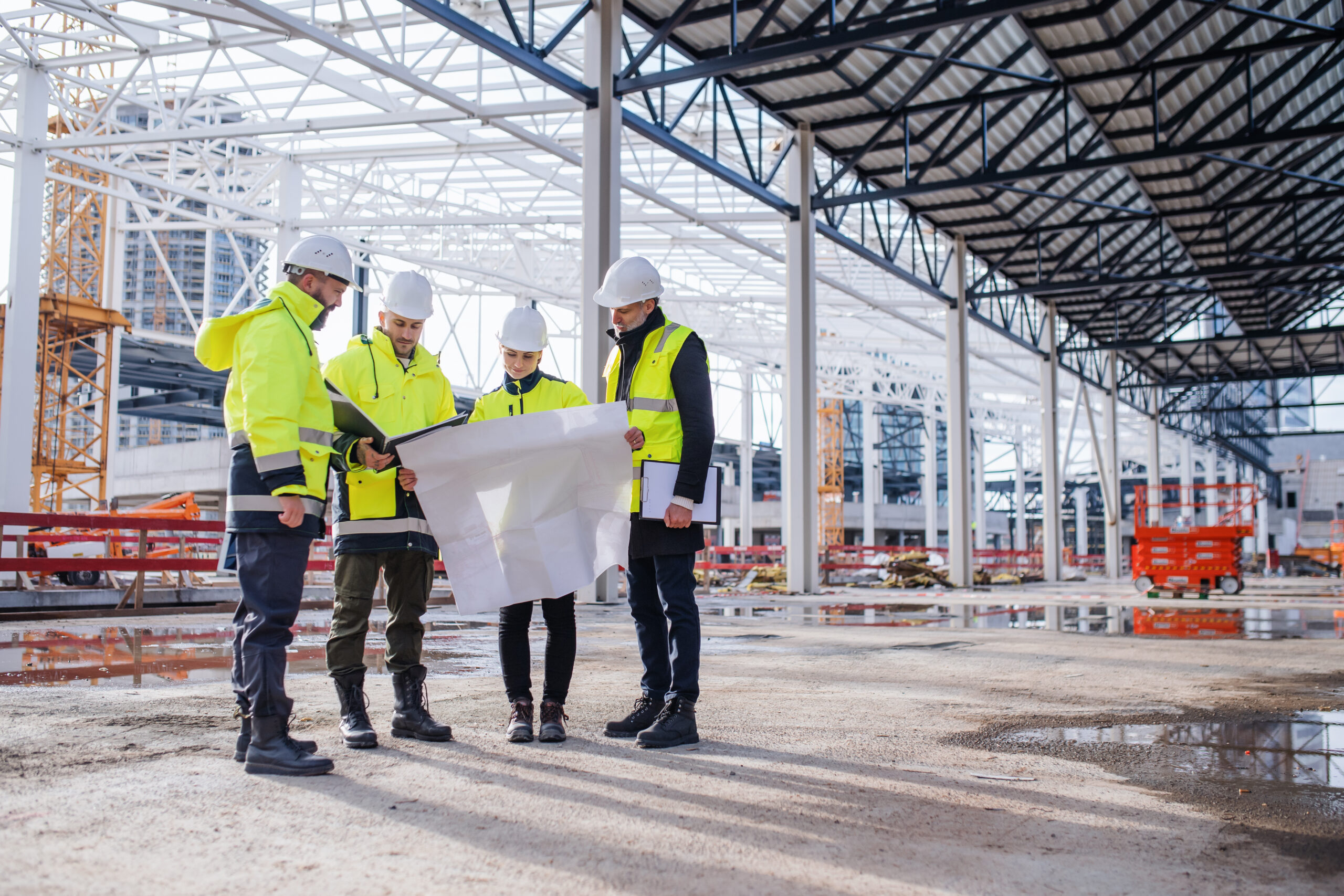 group on construction site reviewing plans